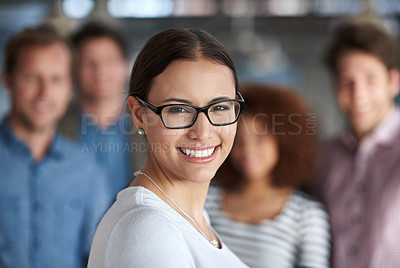 Buy stock photo Smiling young woman looking at the camera with staff in the background