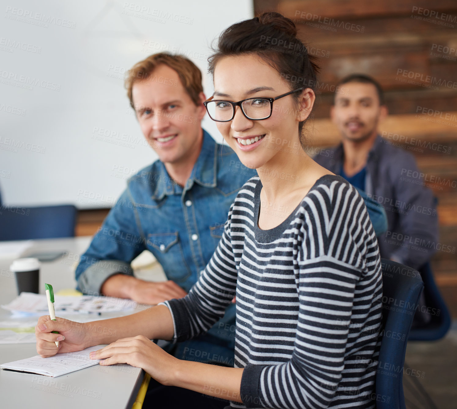 Buy stock photo Portrait of an attractive young woman sitting in an office with colleagues in the background