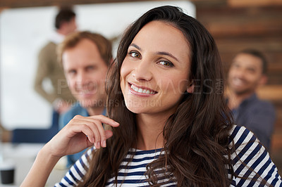 Buy stock photo Portrait of an attractive young woman sitting in an office with colleagues in the background