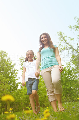 Buy stock photo A daugher and mother walking in a meadow spending quality time together