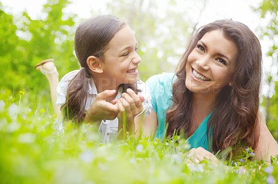 Buy stock photo A mother and daughter lying in the grass of a Meadow while sharing a moment