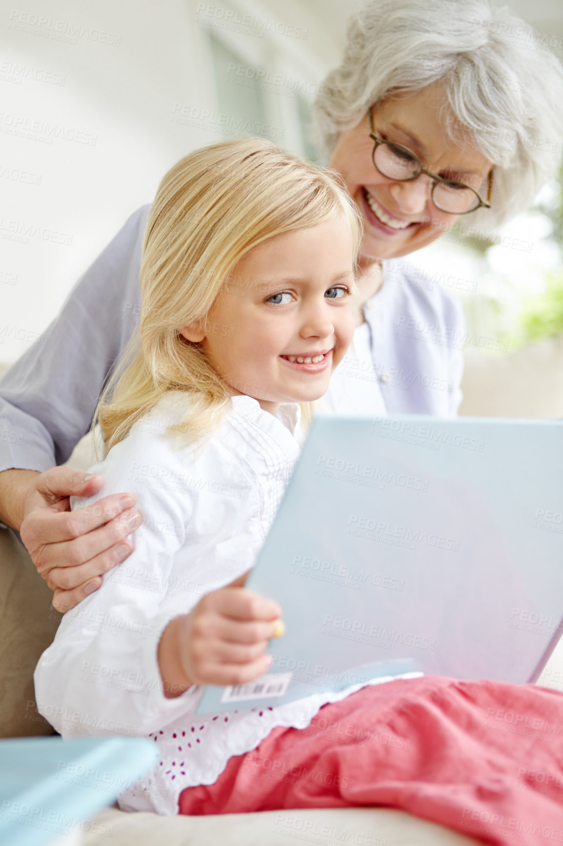 Buy stock photo Girl, senior grandma and fantasy book in home living room with woman, smile and story for retirement on sofa. Happy, elderly person and weekend for rest, family bonding and lounge for memory on couch