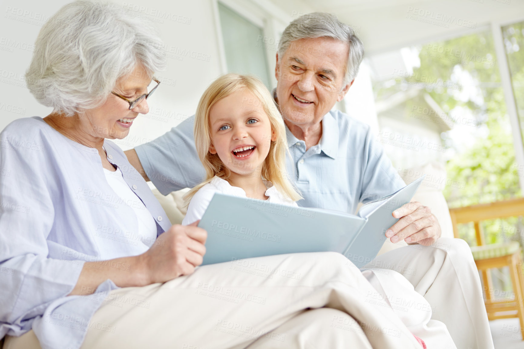 Buy stock photo Grandparents, excited and girl reading book in home for learning, bonding and knowledge together. Grandma, grandfather and happy kid storytelling in family house for fairytale, fantasy or development