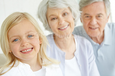 Buy stock photo Happiness, portrait and child with grandparents in family home, retirement or lounge for bonding. Senior people, little girl and together for love in living room or house for growth, support and care