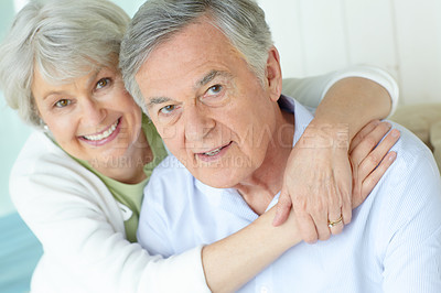 Buy stock photo Hug, portrait and smile of senior couple on sofa in living room of home together for bonding or commitment. Face, love or retirement with old man and woman embracing in apartment for safety or trust