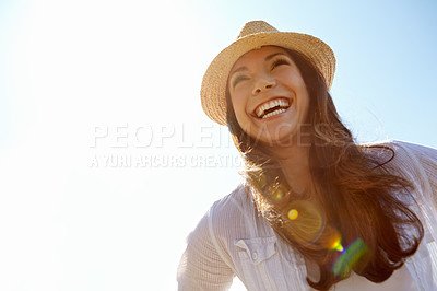 Buy stock photo A beautfiul young woman laughing outdoors against a clear blue sky