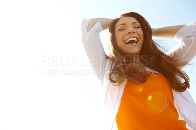 Buy stock photo A beautfiul young woman laughing outdoors against a clear blue sky