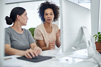 Buy stock photo Shot of two creative businesspeople working together on a computer in the office