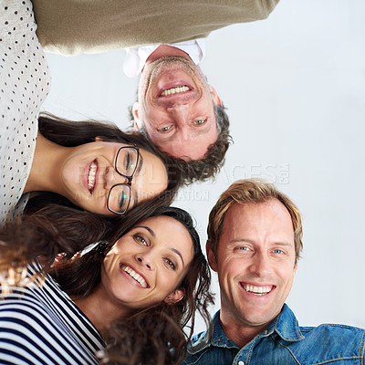 Buy stock photo Low angle shot of four people smiling down at the camera positively
