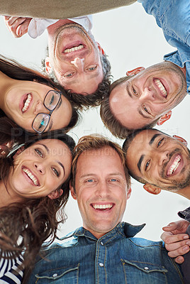 Buy stock photo Cropped low angle shot of six people putting their heads together in a circle