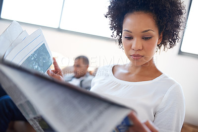 Buy stock photo Low angle shot of a businesswoman reading a newspaper on her lunch break