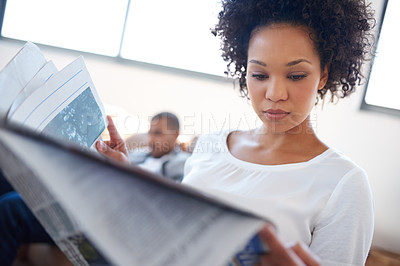 Buy stock photo Woman, reading and newspaper on sofa for information, article or knowledge on politics in living room. Publication, update and person with man for global events, newsletter or trending story in home