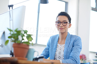 Buy stock photo Intelligent young woman looking at the camera while sitting at her desk