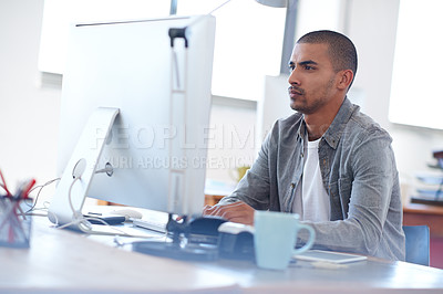 Buy stock photo Young creative man at work on his pc in a bright open office