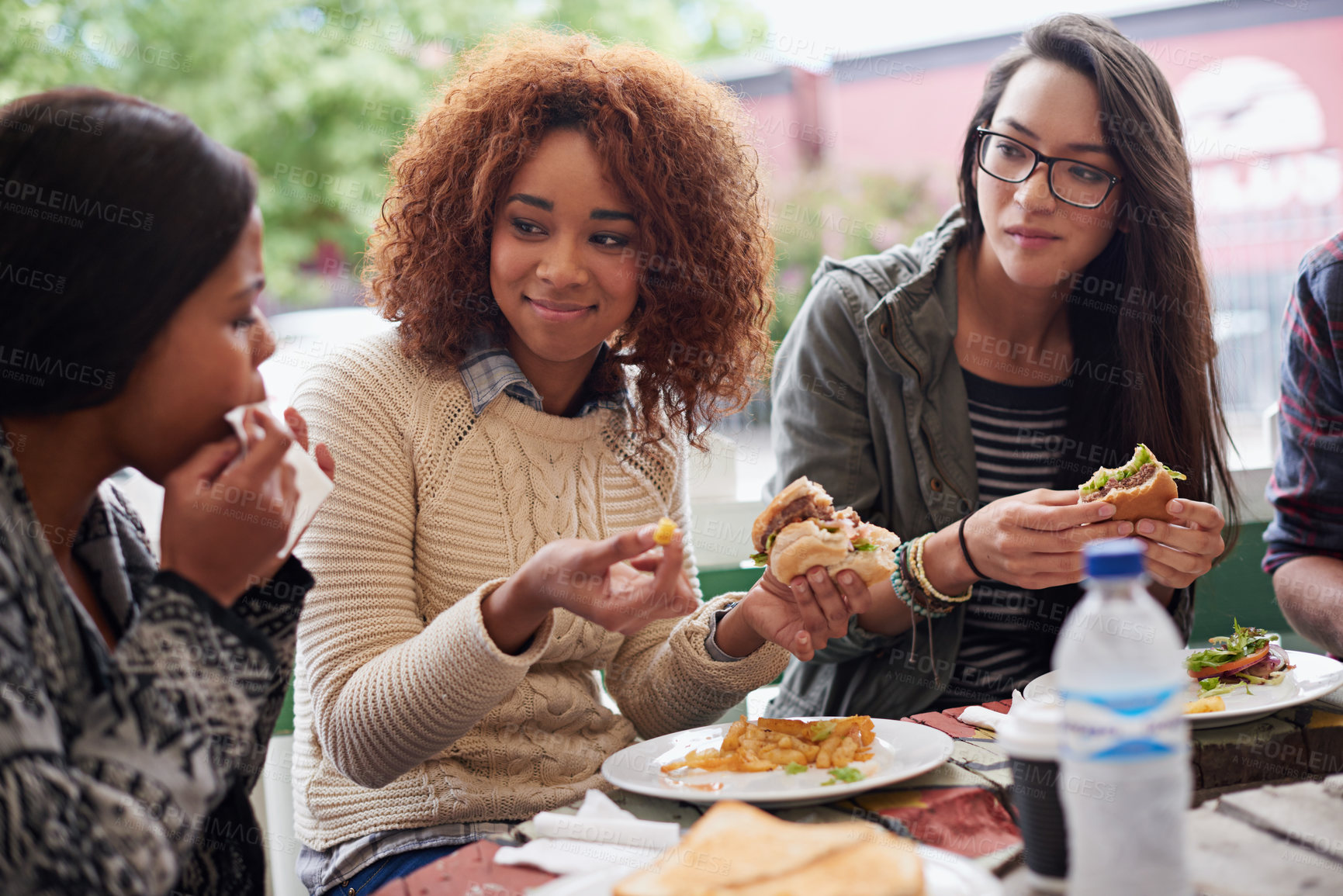 Buy stock photo Cropped shot of a friends eating burgers outdoors