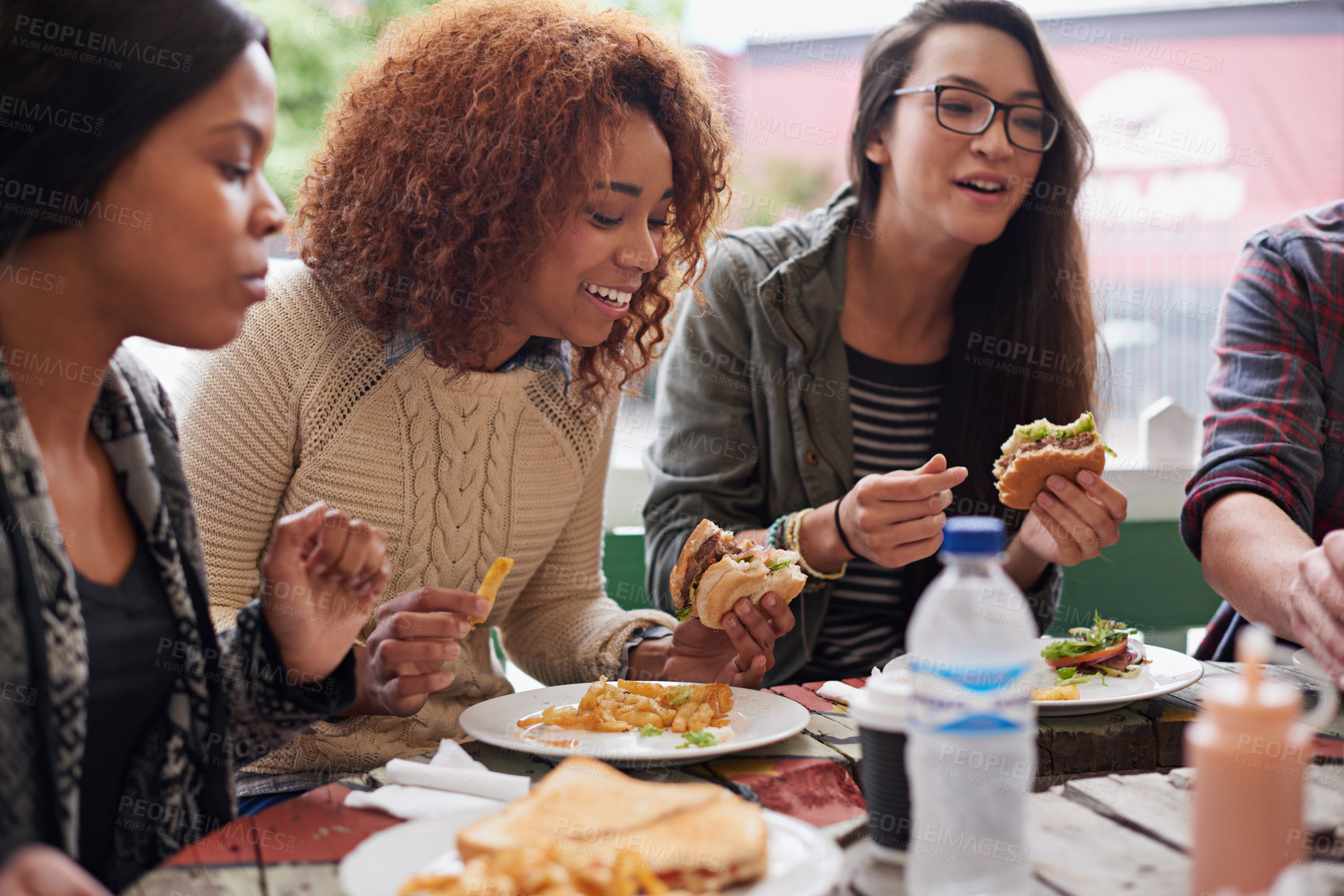 Buy stock photo Restaurant, group and friends eating, social gathering and reunion with conversation and happiness. Diversity, women and student on a break, fast food and snack with lunch and smile with discussion