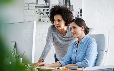 Buy stock photo Cropped shot of two casually dressed businesswoman looking at something on a computer screen