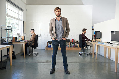 Buy stock photo Young businessman standing in the middle of a bright contemporary office space