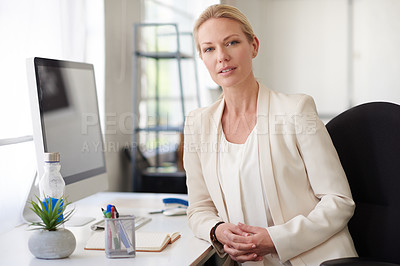 Buy stock photo Serious creative professional woman looking intently at the camera while sitting at her desk