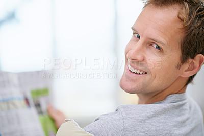Buy stock photo Man, newspaper and relax in home portrait, calm and comfortable on weekend in living room. Happy male person, reading and article in apartment, information and rest on couch in pyjamas for story