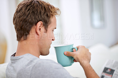 Buy stock photo Cropped shot of a handsome drinking coffee while reading a newspaper