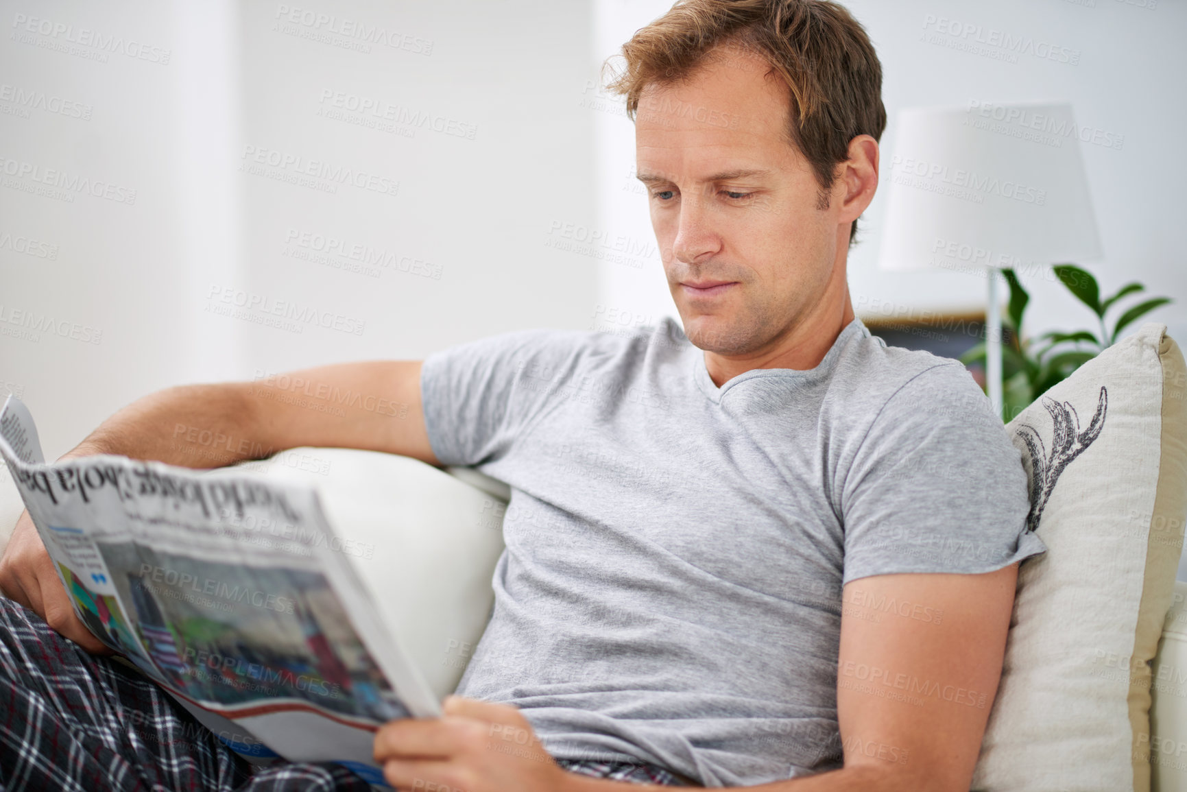 Buy stock photo Man, newspaper and relax on sofa for peace, calm and comfortable on weekend in living room. Male person, reading and media article in apartment, information and rest in home for print story update