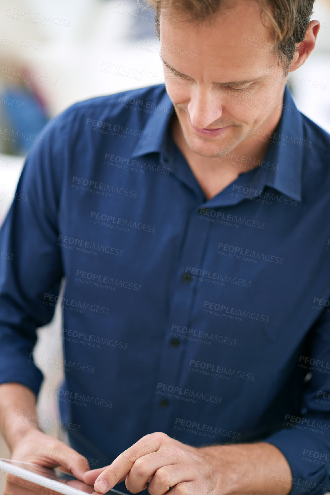 Buy stock photo Shot of a handsome man using his tablet at home