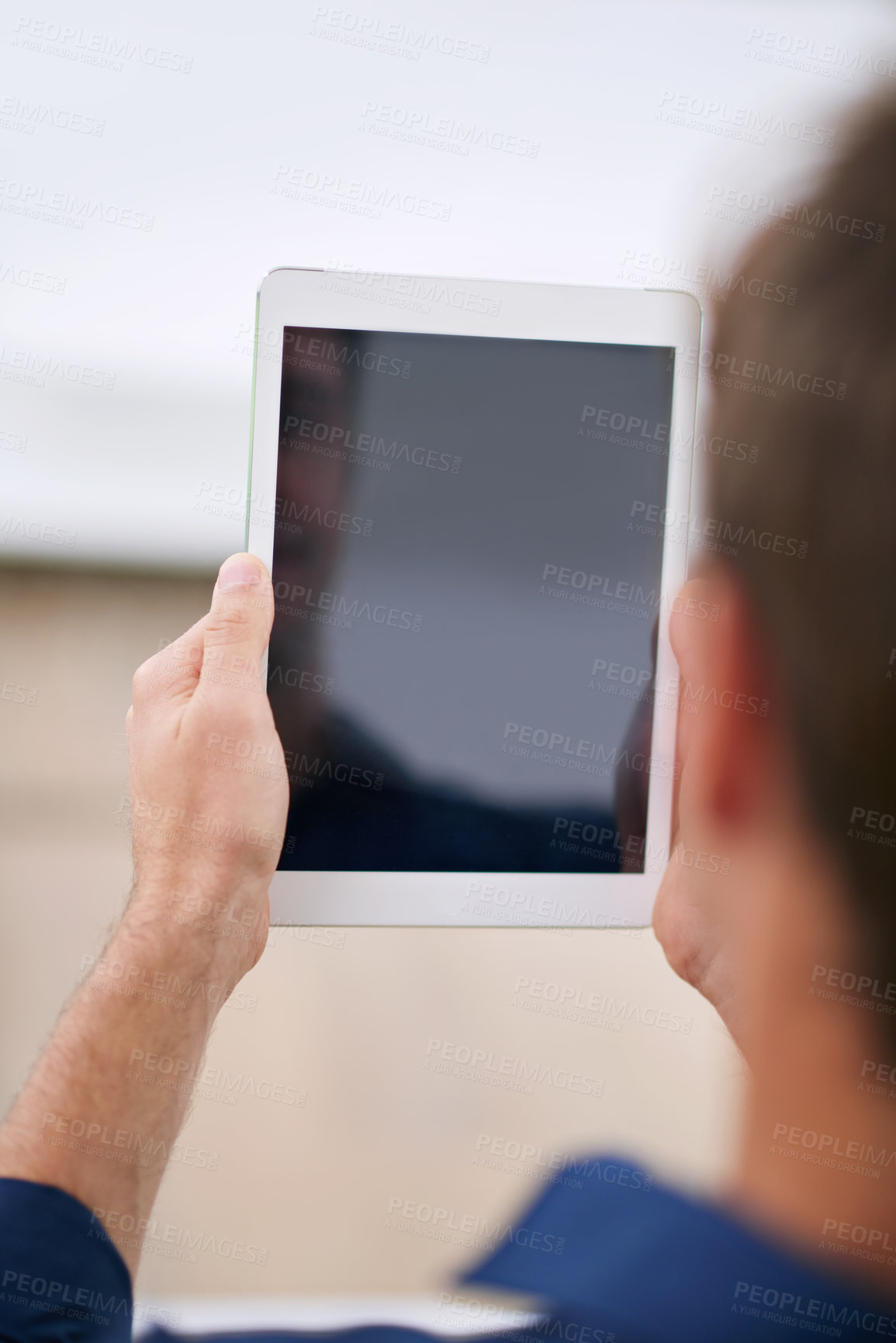 Buy stock photo Over the shoulder shot of a man using a digital tablet