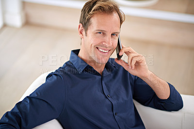 Buy stock photo Portrait of a handsome man talking on his mobile phone at home