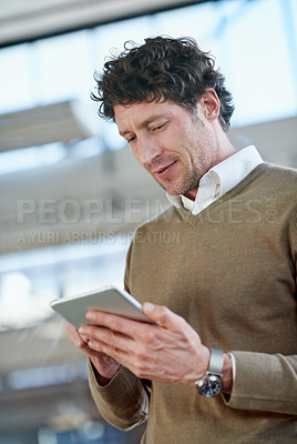Buy stock photo Cropped shot of a casually-dressed businessman using a digital tablet