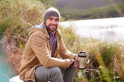 Buy stock photo Camping, portrait and man with coffee by lake in nature for adventure, travel and outdoor vacation. Holiday, smile and male person with hot beverage for relax, peace and winter morning in countryside