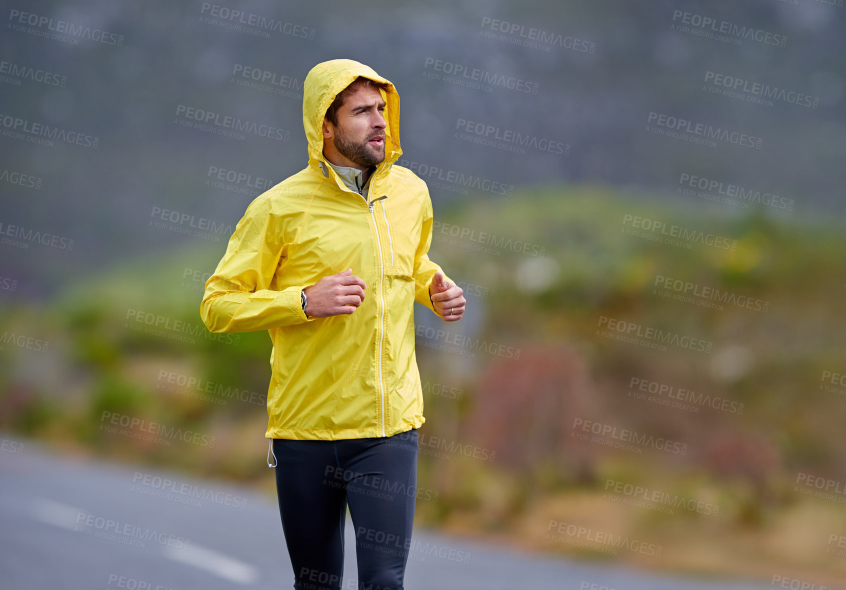 Buy stock photo Shot of a handsome young man running in rainy weather
