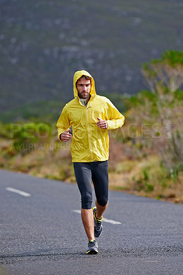 Buy stock photo Running, rain and man with challenge, fitness and endurance with workout and cardio. Road, runner and athlete with sports and training with wind and nature with exercise, coat or practice with health