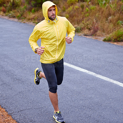 Buy stock photo High angle shot of a handsome young man running in rainy weather