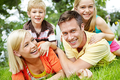 Buy stock photo Happy young family lying together on the grass at home