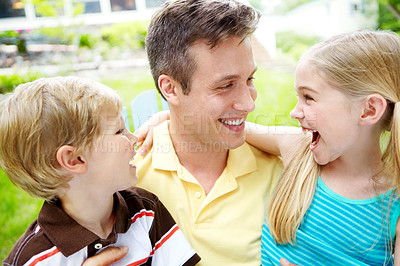 Buy stock photo Handsome young father holding his two children with a happy smile