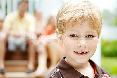 Buy stock photo Cropped portrait of a cute little boy with his family in the background 