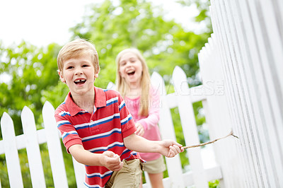 Buy stock photo Happy children, siblings or running with stick for playful summer together in nature or backyard. Young, brother and sister with smile for fun childhood, bonding or holiday weekend in garden by fence