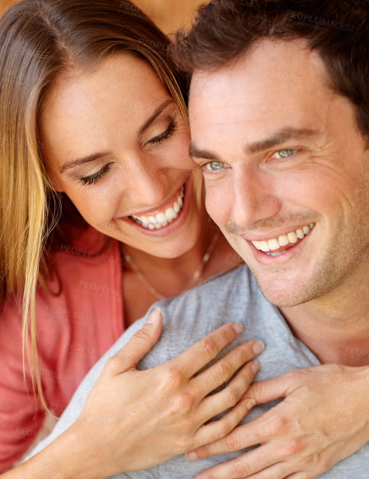 Buy stock photo A happy young couple sitting on the couch embracing lovingly