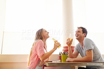 Buy stock photo A happy young couple enjoying an alcoholic drink in a restaurant