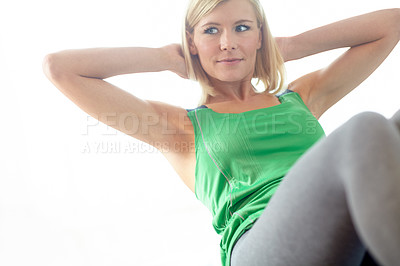 Buy stock photo Cropped view of a young blonde woman in sportswear at home doing some sit ups