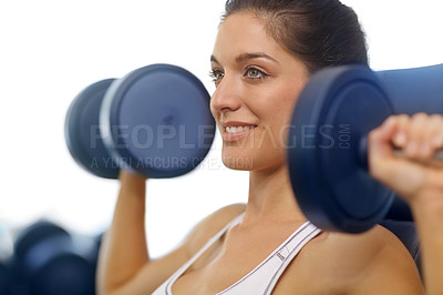 Buy stock photo A beautiful young woman exercising with weights at the gym