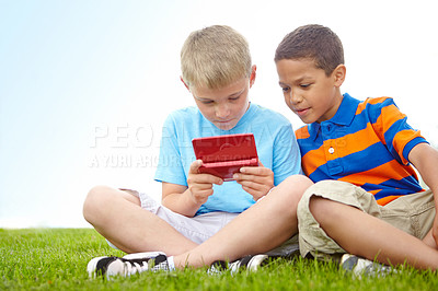 Buy stock photo Park, kids and boys with gaming console for playing together, video games or bonding on field. Male friends, outdoor and children with portable technology for entertainment, fun or development growth