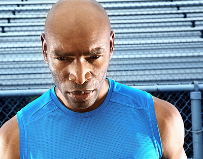 Buy stock photo Cropped shot of a male runner at the race track looking away from the camera and wearing sports clothing