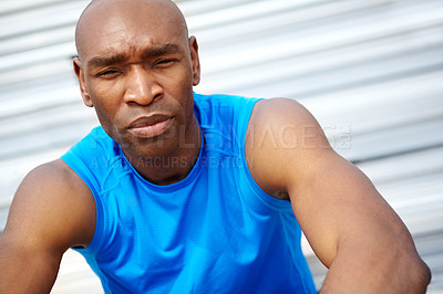 Buy stock photo Cropped close up portrait of a male runner sitting on the rafters at the track
