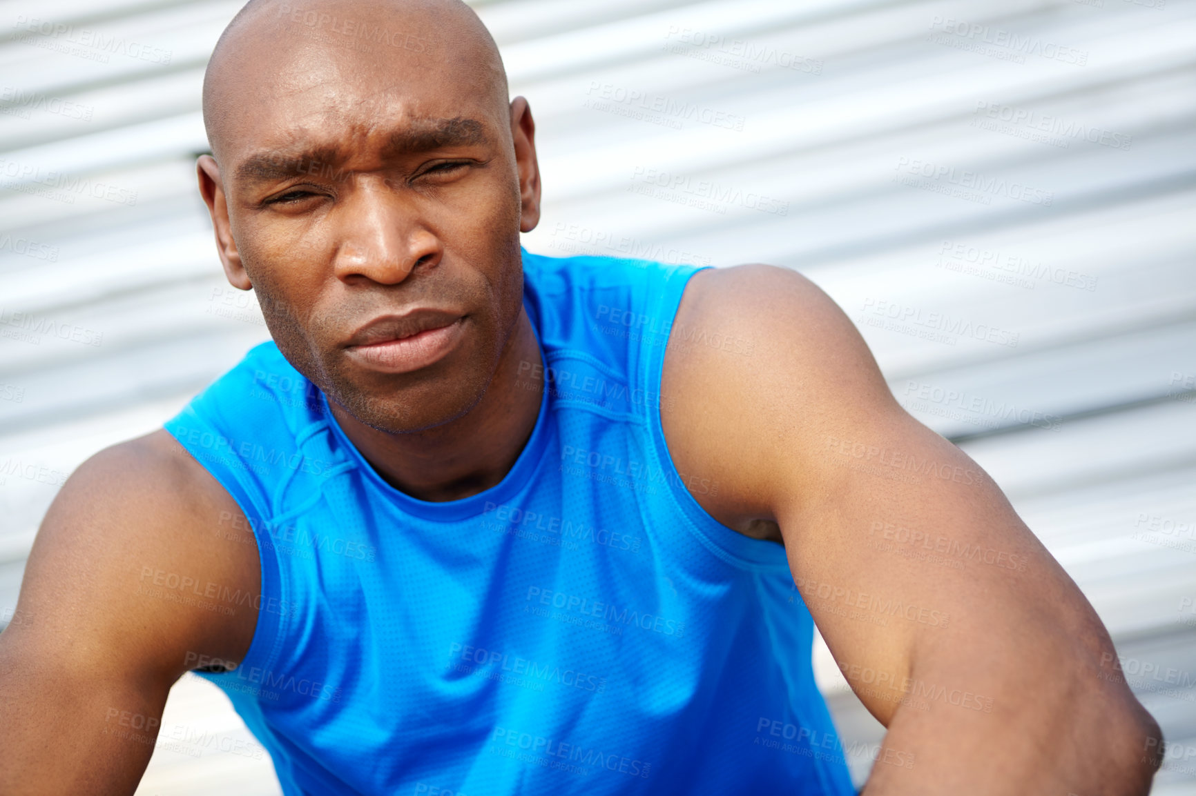 Buy stock photo Cropped close up portrait of a male runner sitting on the rafters at the track