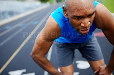 Buy stock photo Cropped close up of a male athlete at the start of the track