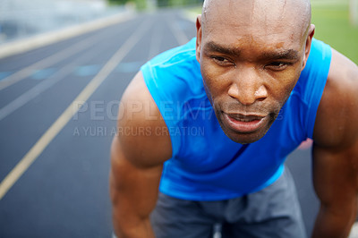 Buy stock photo Cropped close up of a male athlete looking away from the camera at the start of the track