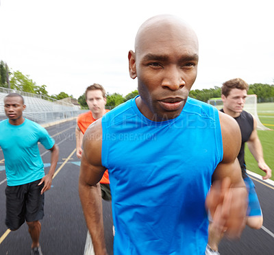 Buy stock photo Cropped front view of a focused male athlete with competitors in the background