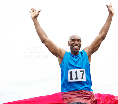 Buy stock photo Cropped front view of a male athlete winning a race with his arms raised and a smile on his face